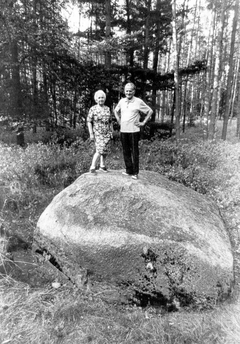 Erna und Kurt Kretschmann stehen gemeinsam auf einem Findling im Wald